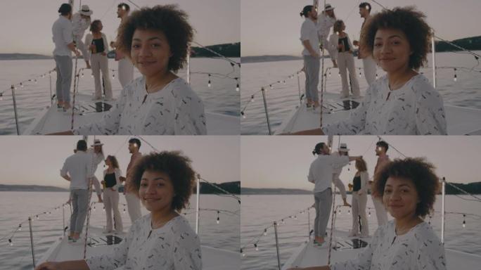 SLO MO年轻女子摆姿势，而她的朋友聚集在船的背景下