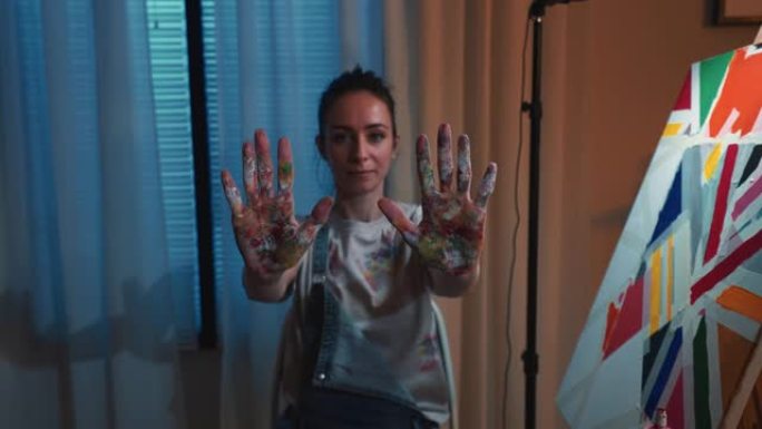 一位女艺术家展示脏手的肖像。