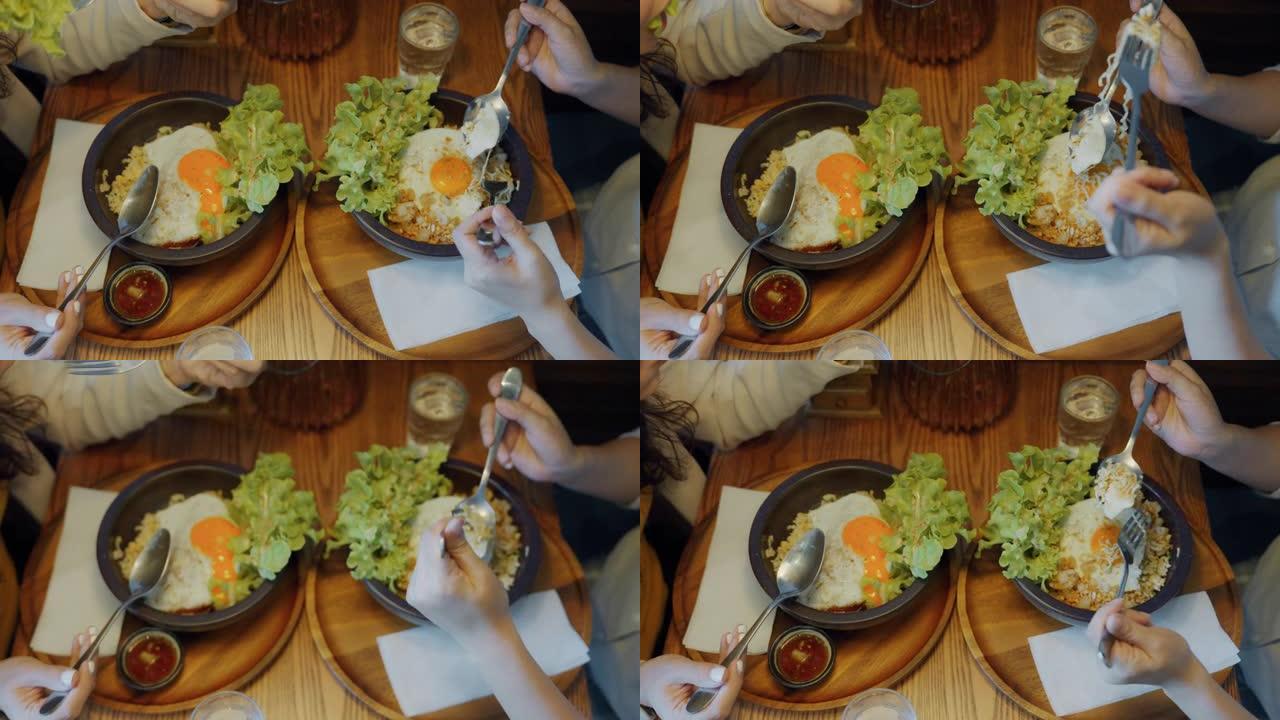 餐桌上有煎蛋和蔬菜的炒饭盘的俯视图。