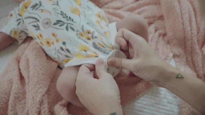 母亲和婴儿穿衣服妈妈给婴儿穿衣服特写视频