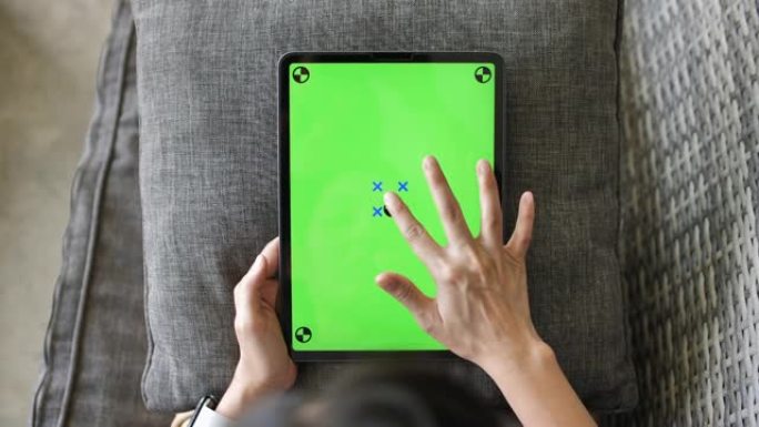 女人在绿色模拟屏幕数字平板电脑上使用手势