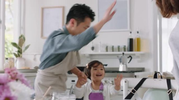 快乐的亚洲家庭在厨房跳舞，让孩子们高五岁，与父母一起跳舞，享受激动人心的周末在家庆祝活动4k镜头