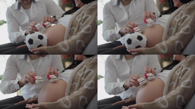 DS男子在怀孕妻子的肚子上踢小婴儿鞋踢足球