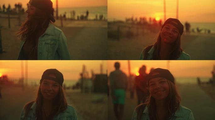 棕色头发的年轻女子，从海滩走回家，对着镜头微笑，美丽的日落，背景中有很多人
