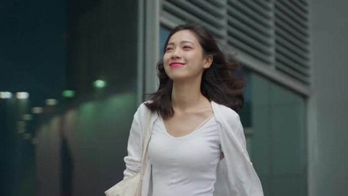 年轻漂亮的亚洲女人走在城市街道上