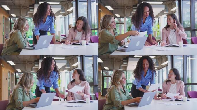 多文化女性商业团队会议坐在现代办公室的办公桌上，使用慢动作的笔记本电脑拍摄