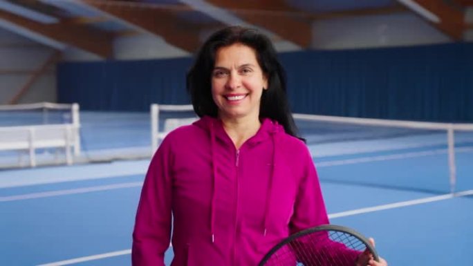 网球场上微笑的西班牙裔成熟女人的肖像