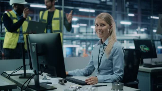 汽车厂办公室: 在台式电脑上工作的女工程师的肖像，微笑着竖起大拇指的手势。自动化机器人手臂装配线制造