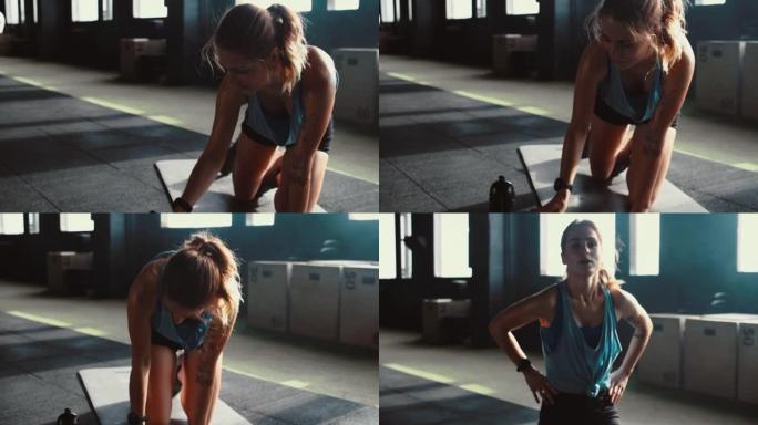 健身追踪器移动应用快乐美丽成功的年轻运动型女性使用智能手机在轻型健身房锻炼。