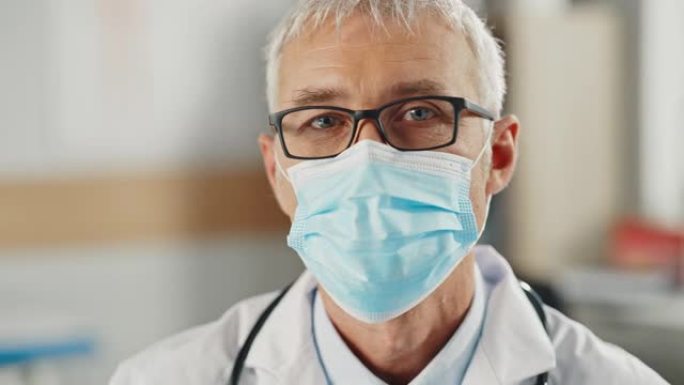 一位戴着防护口罩和眼镜的高级高加索男性医生或外科医生的特写肖像。中年科学家冷静地看着相机。新型冠状病