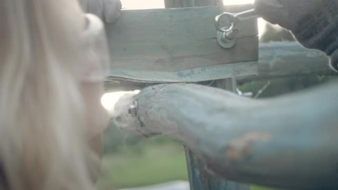 女人建造木制凉棚。使用扳手。花园DIY项目