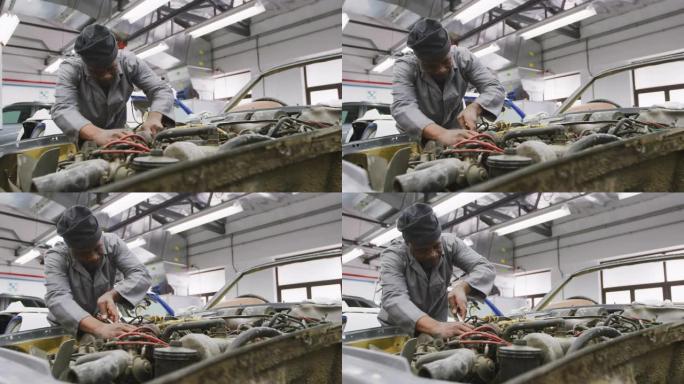 非裔美国男性汽车机械师在汽车发动机上拧螺丝