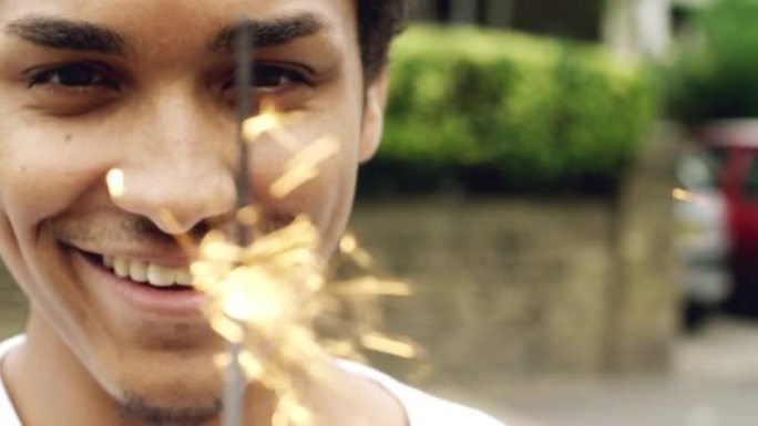 4k视频片段，一个英俊的年轻人独自站在城市外面玩烟火