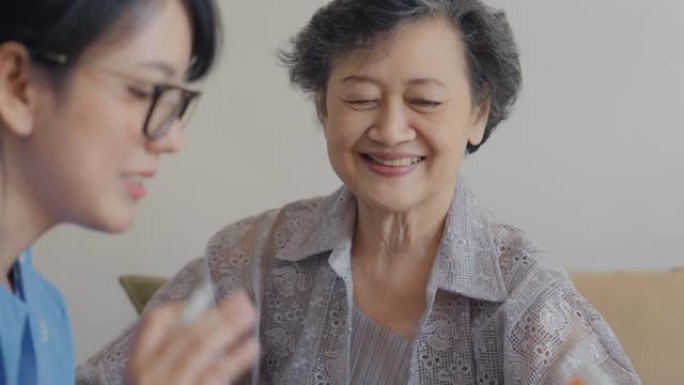 女医生正在向老年妇女解释药物。