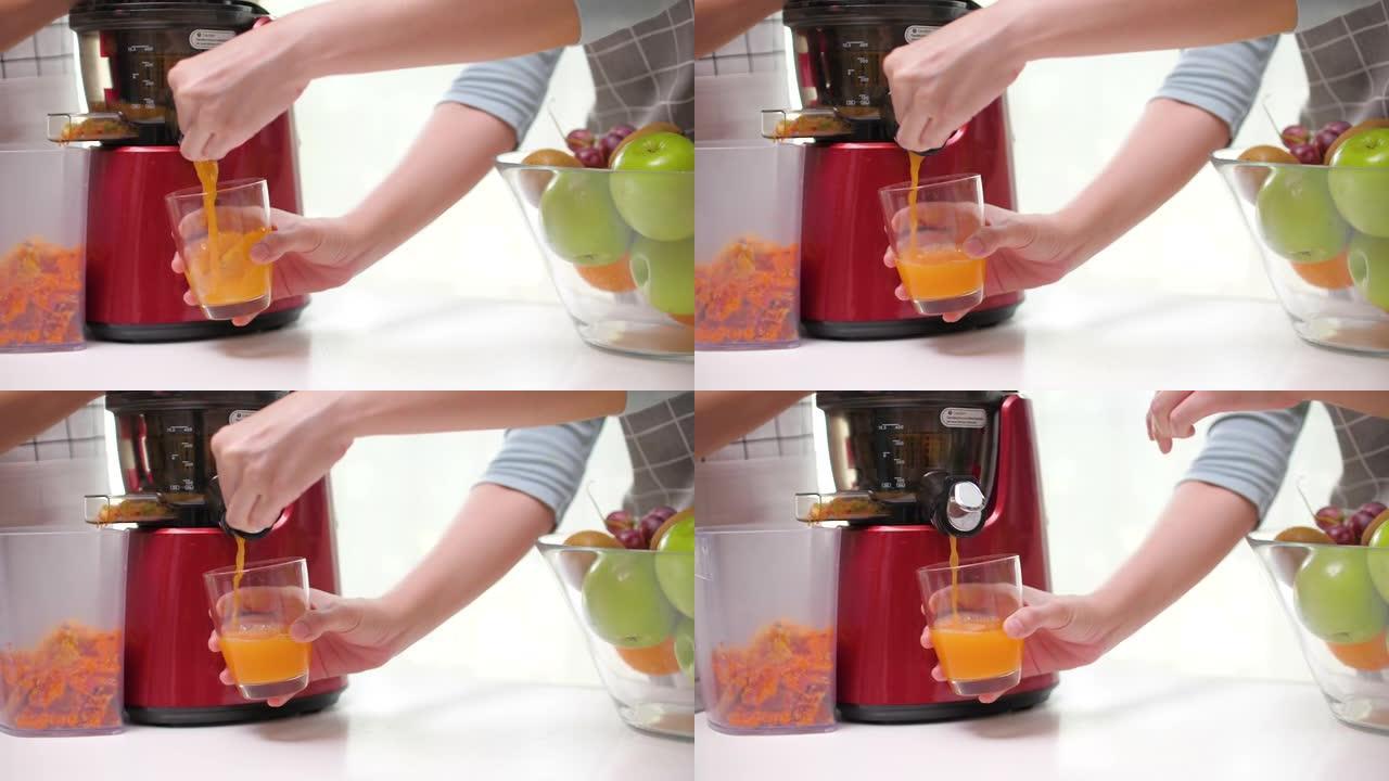 冷榨果汁与苹果橙和胡萝卜在冷榨机中混合