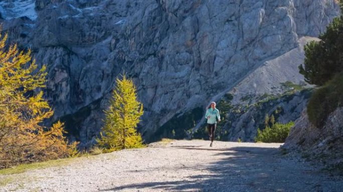 健康的女运动员保持健康的生活方式，在周围风景优美的山区跑步