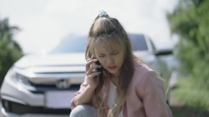 年轻女子在汽车故障和使用手机打电话在路上服务方面有问题