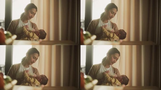 美丽的亚洲母亲在家中用奶瓶给婴儿喂奶的肖像。年轻女子初生与婴儿建立联系并享受深情的时刻