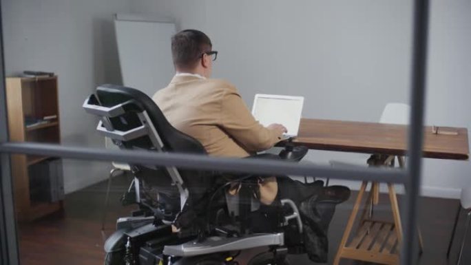 坐在轮椅上的男子在办公室工作
