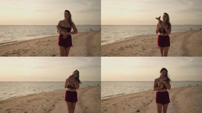 年轻女子和她的小狗一起在海滩上享受