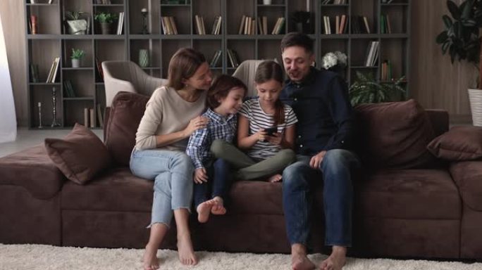 幸福的两代人家庭在家里一起使用手机。