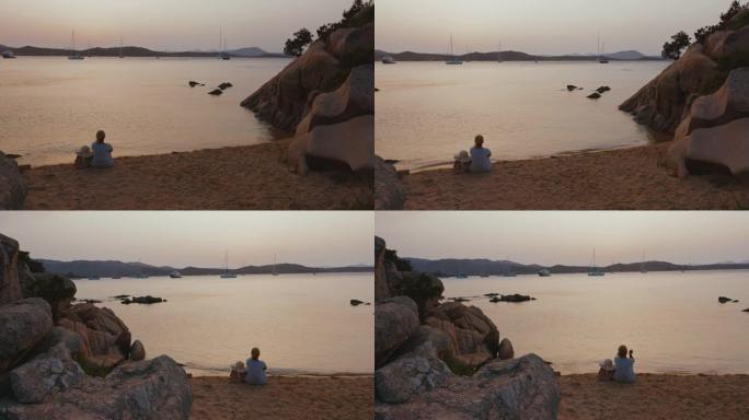 意大利撒丁岛，一个坐在海滩上的女人的景色。