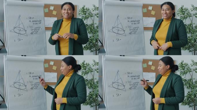 数学导师教授几何指向挂图演讲在教室里看着室内的相机