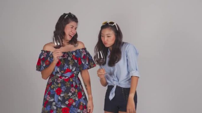 时尚的亚洲中国夏季服装与酒杯跳舞工作室拍摄与灰色背景剪裁