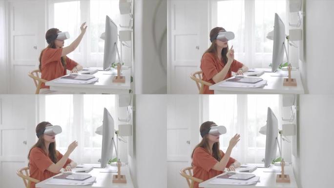 美丽的亚洲女性年龄36岁坐在家庭办公室戴着虚拟现实护目镜，触摸空气在虚拟现实体验和电脑远程工作。成人
