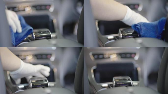 汽车抛光工人用超细纤维毛巾擦拭汽车控制台。