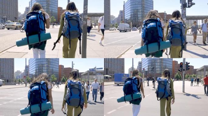两名背包客在柏林市波茨坦广场行走的后视图
