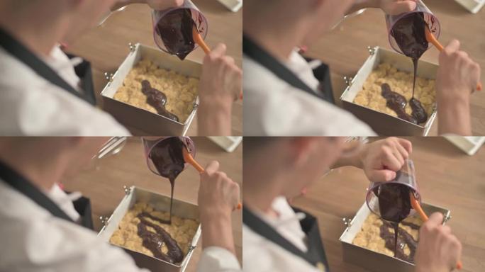 亚洲中国甜点厨师将融化的巧克力倒入脆饼托盘中