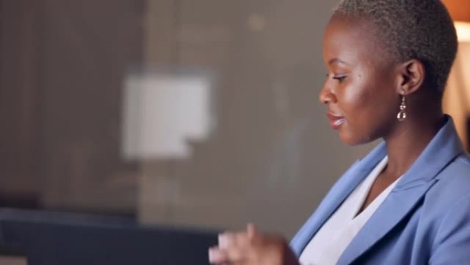 晚上，电脑和黑人妇女在晚上在黑暗的办公室工作时从文件夹中读取信息。公司和非洲工人在加班提案的截止日期