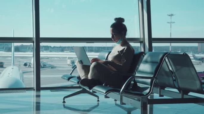 一位女士在等待飞行时正在笔记本电脑上工作