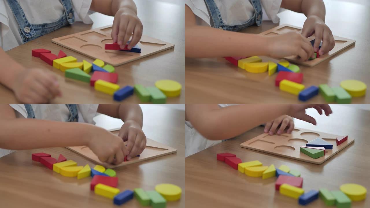 特写，6-7岁的亚洲女孩孩子在家里玩五颜六色的木制玩具积木。家庭教育和远程学习