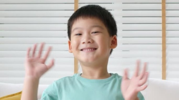 年轻的亚洲小可爱的小孩微笑喜欢向相机挥手。