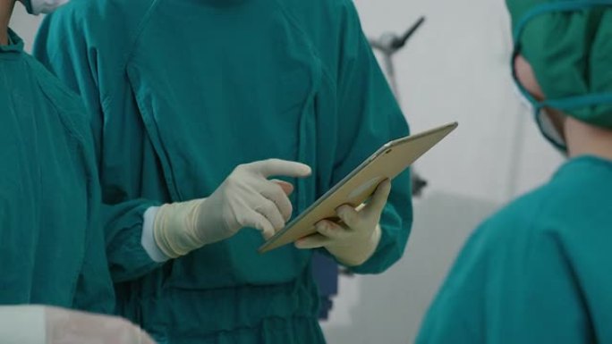 手术室的一组医生用平板电脑检查数据是手术前准备的一项研究。