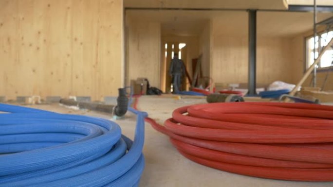 低角度: 彩色橡胶软管盘绕在建筑工地的地面上。