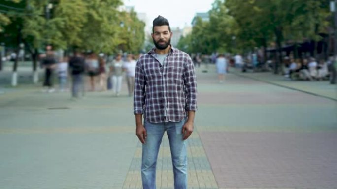 吸引人的中东男子独自站在路过的人中的放大延时肖像