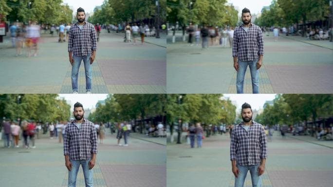 吸引人的中东男子独自站在路过的人中的放大延时肖像