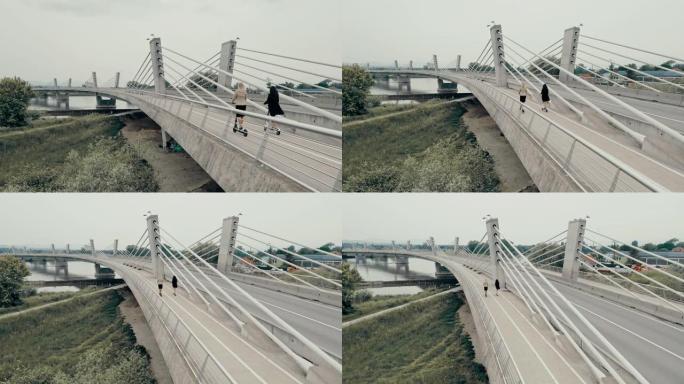 空中两名女商人在桥上骑电动踏板车