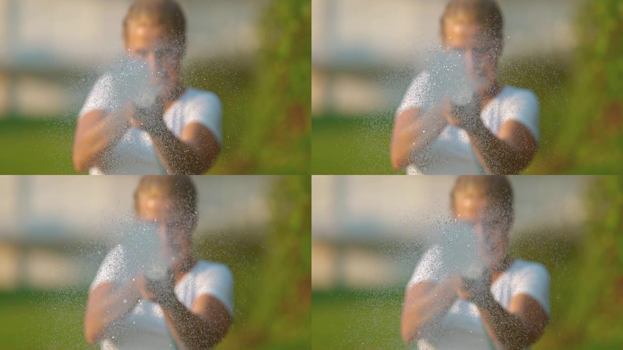 超级SLO MO时间翘曲效果女人在镜头前从花园软管喷水