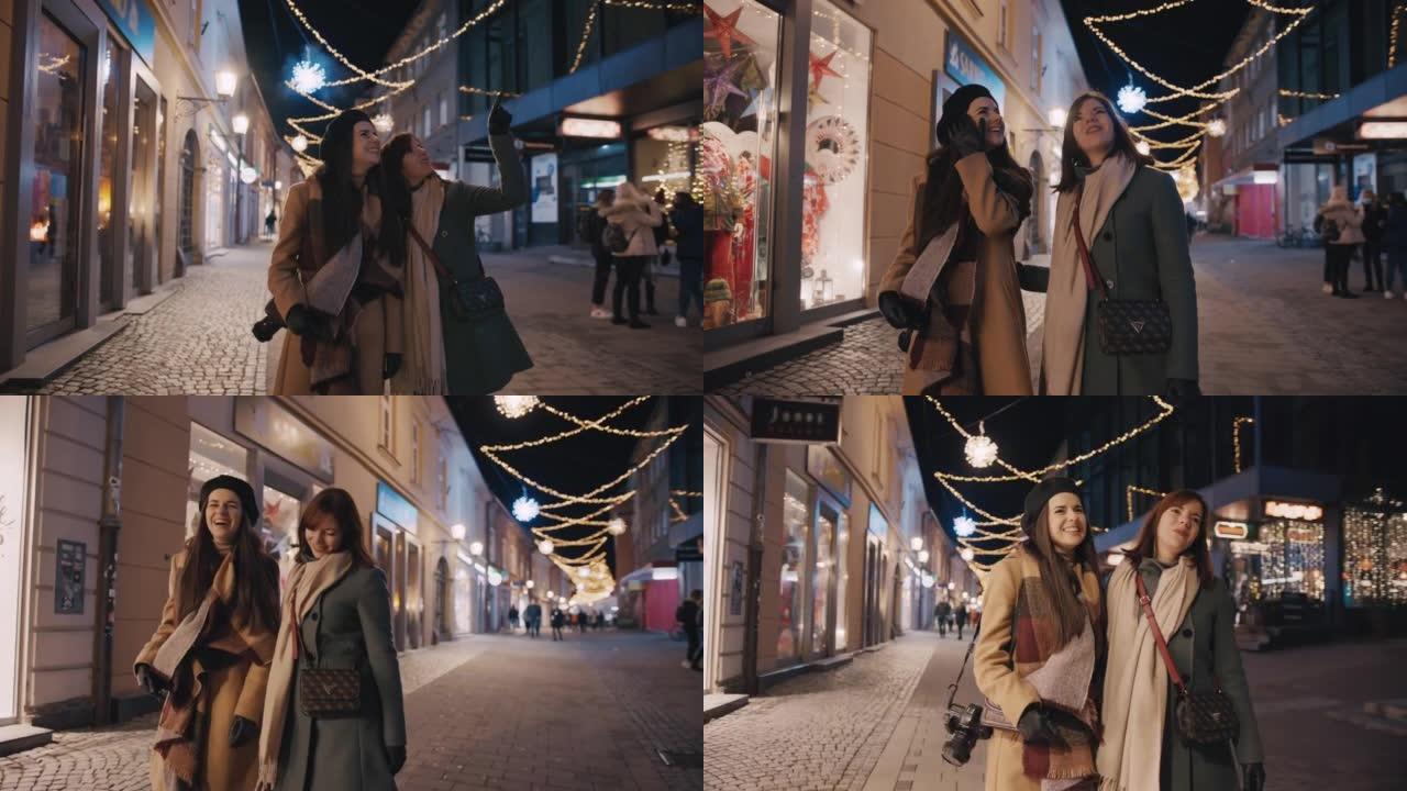 两名年轻女子在圣诞节期间在街上散步时玩得开心