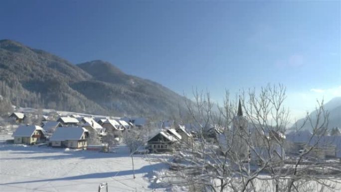 空中: 新鲜降雪后，高山村庄的美丽阳光明媚的冬天早晨