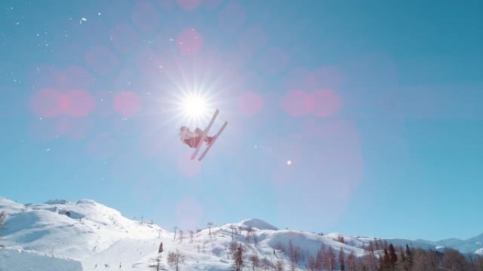 慢动作: 自由式滑雪者在雪地公园跳高后飞得很高