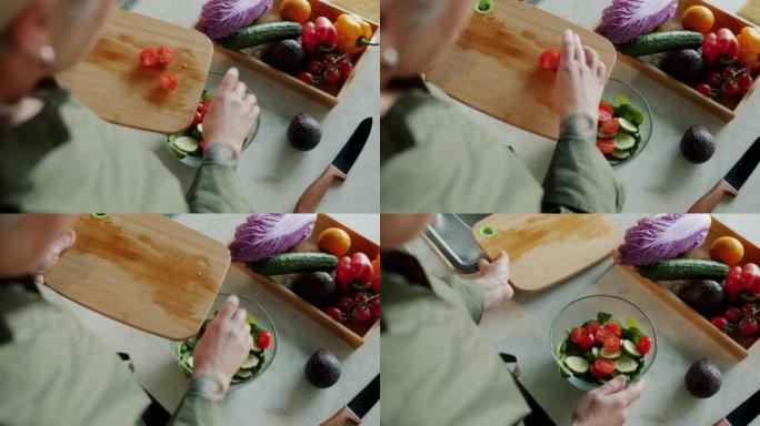 女士手的俯视图将多汁的西红柿放在碗里，用蔬菜沙拉在家做午餐