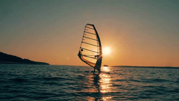 帆船运动员在日落时穿越海洋
