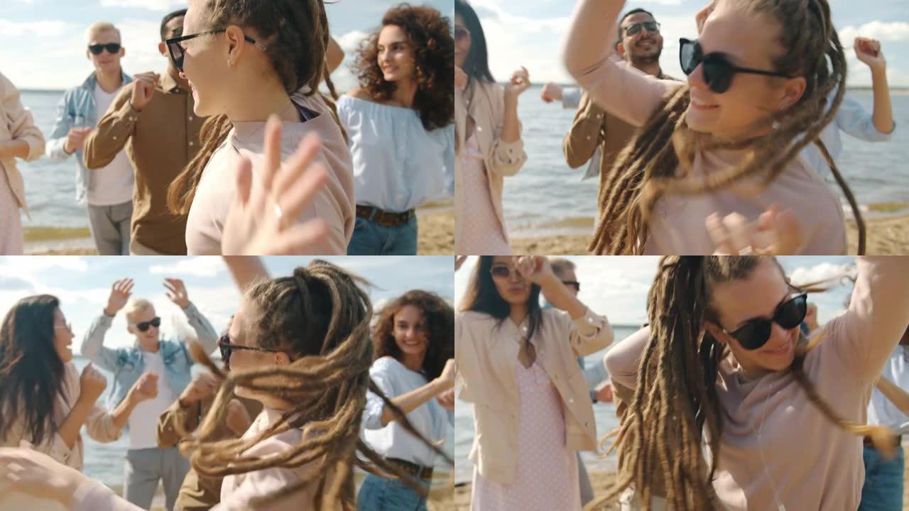 快乐的女孩，留着辫子，在海滩上跳舞，和朋友们微笑着玩得开心