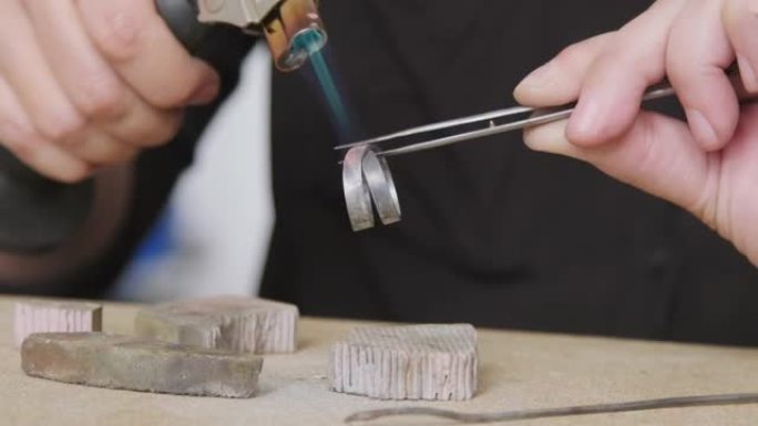 珠宝商的手焊环工作、火焰、手、