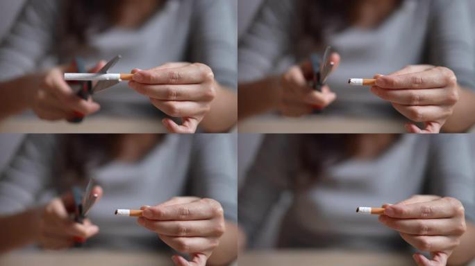 停止吸烟香烟概念肖像美丽的微笑女孩用剪刀剪香烟
